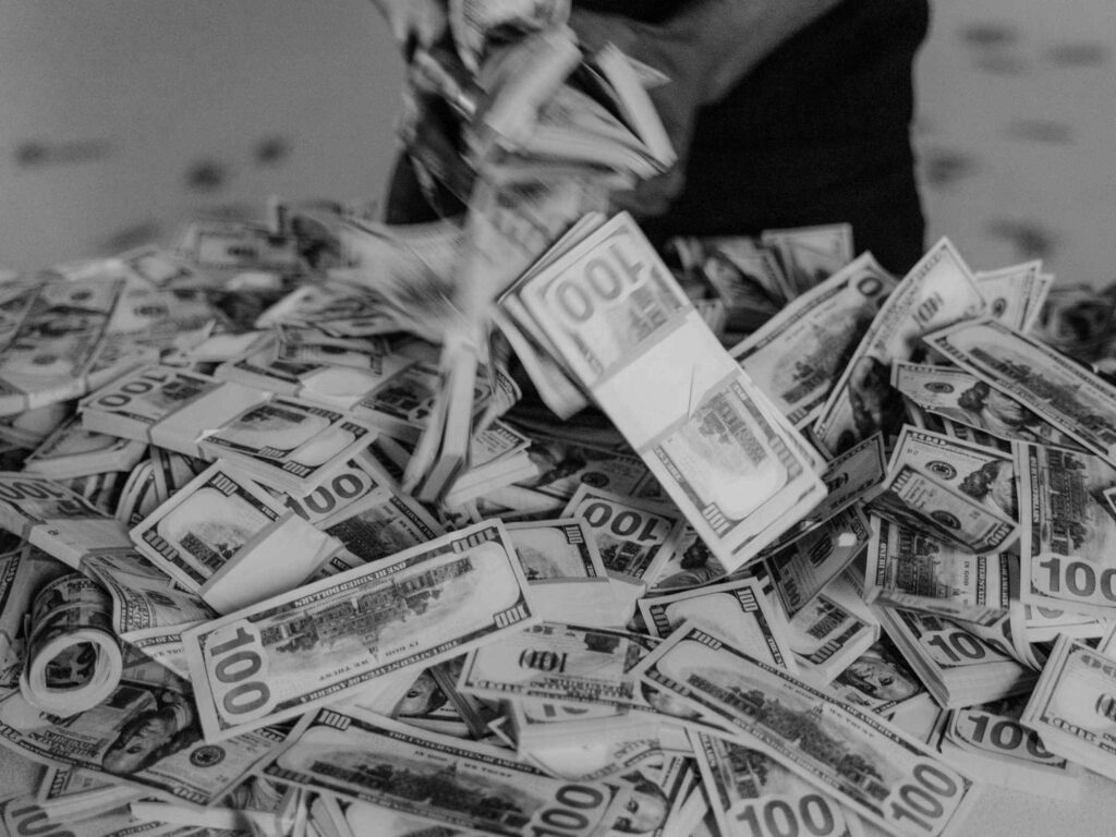 black and white man spilling dollar bills onto the floor